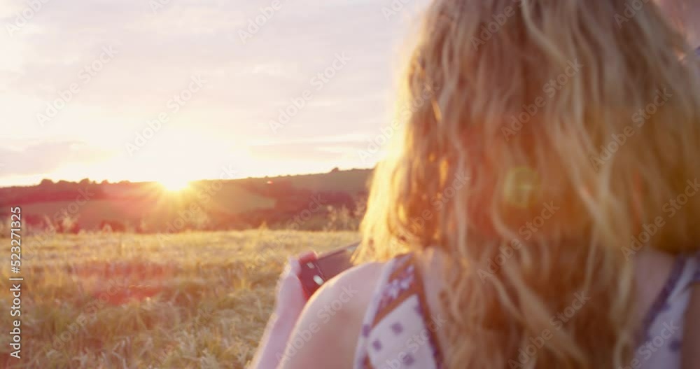 Couple taking a selfie on a phone at sunset outdoors, enjoying free time while bonding in nature. Rear view of boyfriend and girlfriend bonding on a trip away, sharing a special moment together Couple taking a selfie on a phone at sunset outdoors, enjoying free time while bonding in nature. Rear view of boyfriend and girlfriend bonding on a trip away, sharing a special moment together