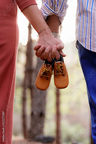 pregnancy announcement with first shoes maternity session outdoor           