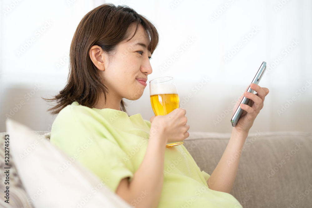 自宅でビールを飲む女性