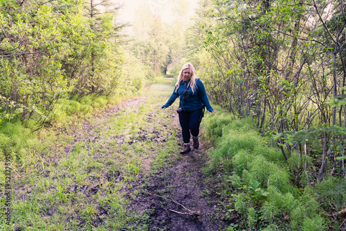 Cautious woman hiker walks through a muddy trail in Kananaskis Country in Alberta Canada photo