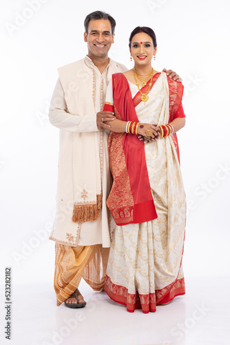 Portrait of happy bengali couple in traditional clothing on occasion of durga puja celebration
 photo