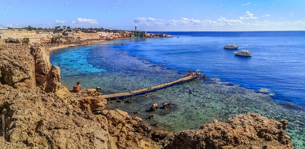 Wideangle panorama of the beach with a coral reef on the Red Sea in Sharm El Sheikh, Egypt. Exotic seascape of luxury Egyptian resort