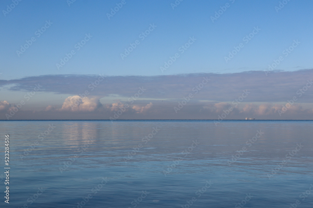 calm ocean waves and cloud reflections and sky