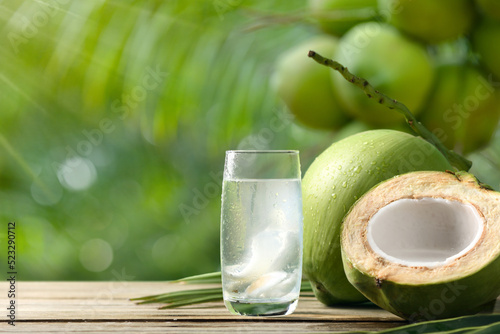 Cool coconut juice with coconut plant background.