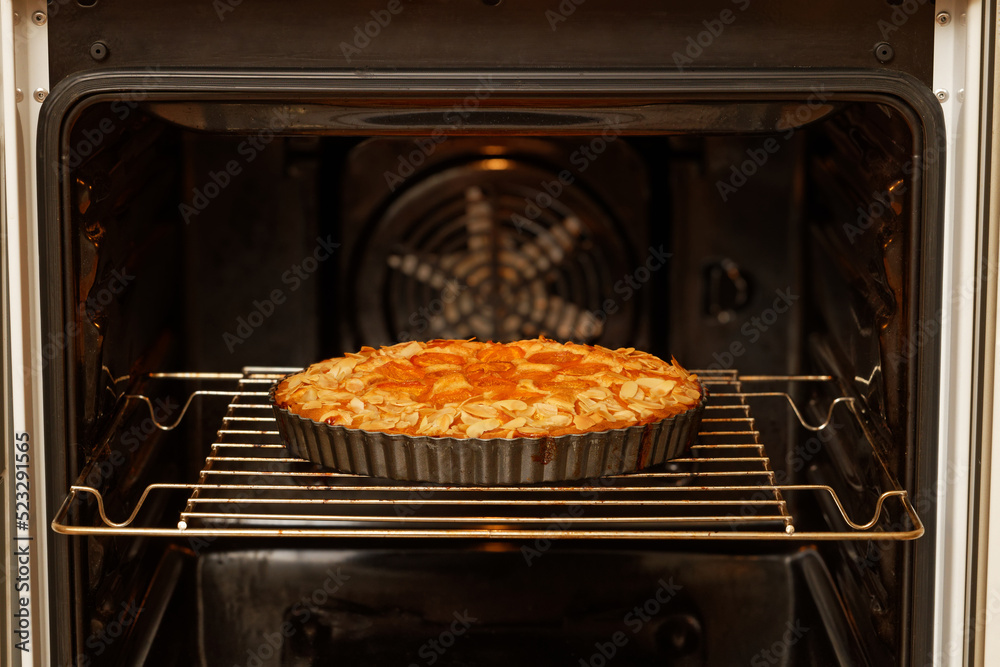 Closeup homemade apricots pie baked in a home oven. Shallow focus.