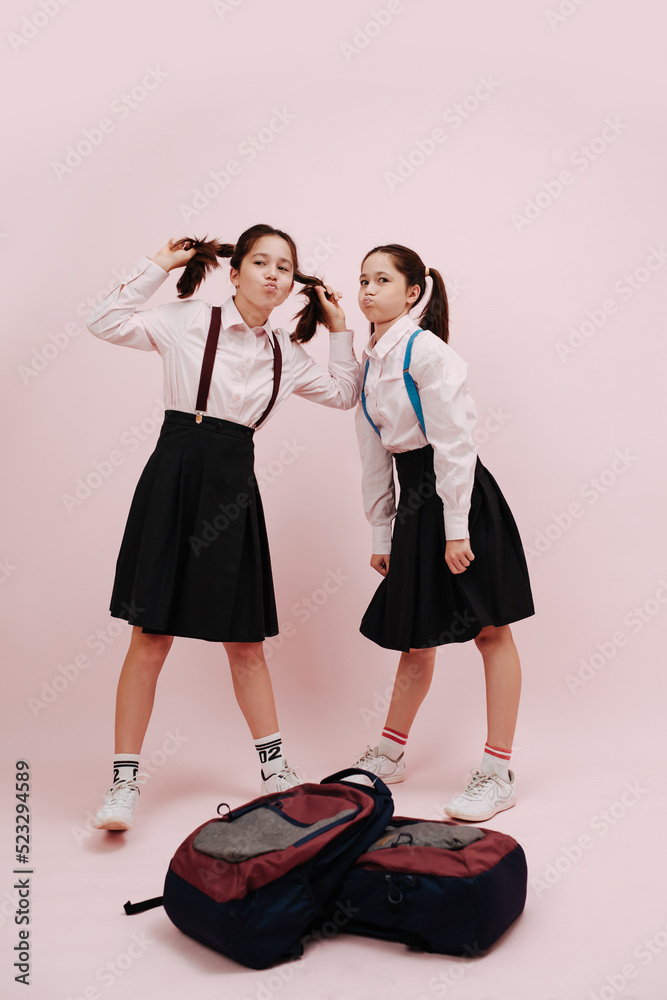 Puffing cheeks twin schoolgirls with twin tails posing for a photo Puffing cheeks twin schoolgirls with twin tails posing for a photo