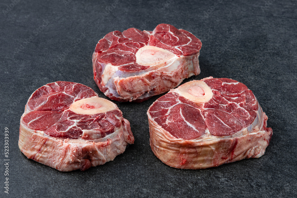 Raw beef meat osso buco shank steak, italian ossobuco. Black background
