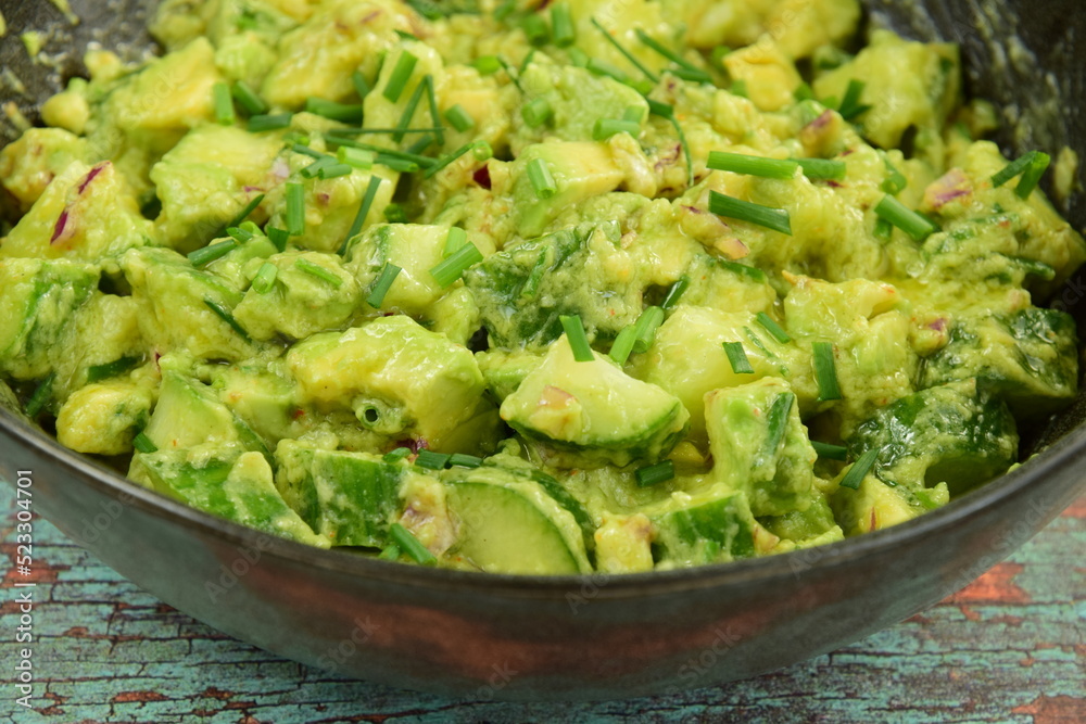 Homemade healthy avocado salad with cucumber, red onion, parsley and avocado lime dressing