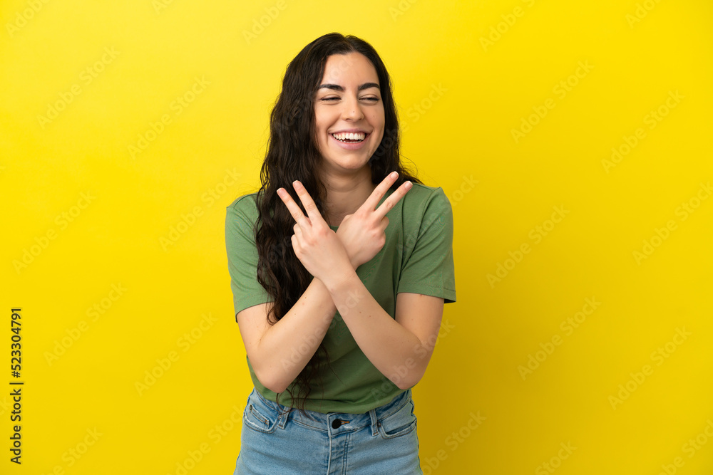 Young caucasian woman isolated on yellow background smiling and showing victory sign Young caucasian woman isolated on yellow background smiling and showing victory sign