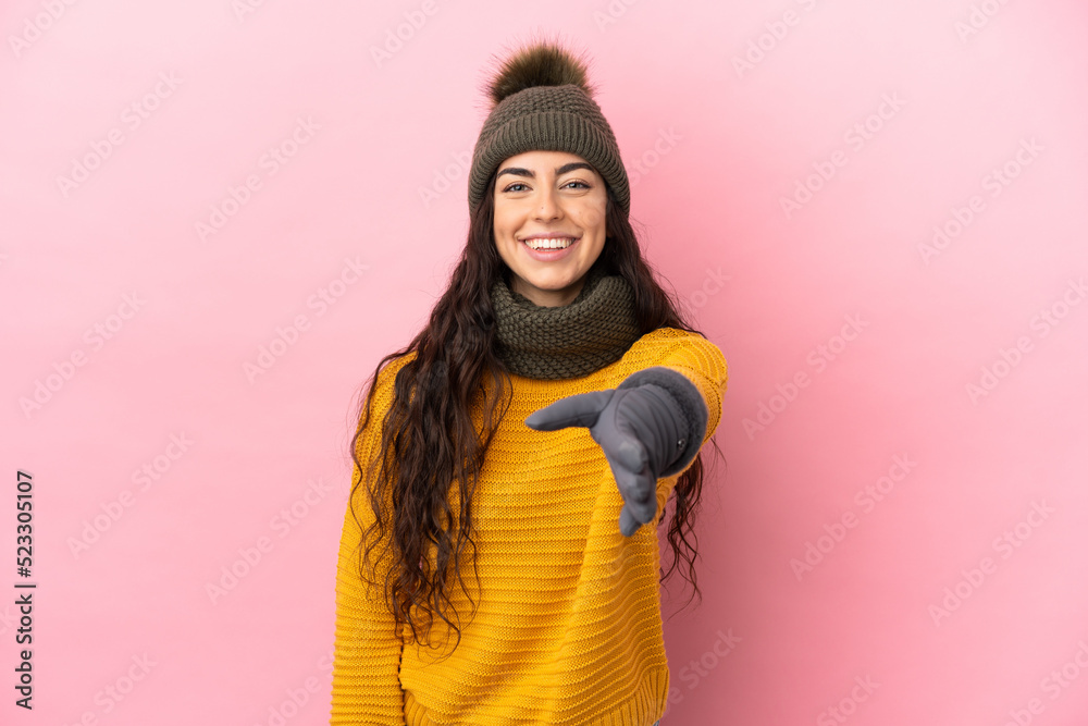 Young caucasian girl with winter hat isolated on purple background shaking hands for closing a good deal Young caucasian girl with winter hat isolated on purple background shaking hands for closing a good deal
