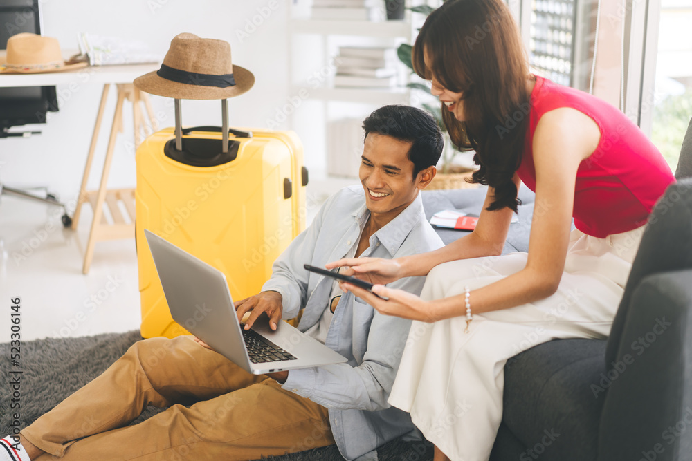 Obraz premium Young adult southeast asian couple using laptop for getting ready for holidays travel trip