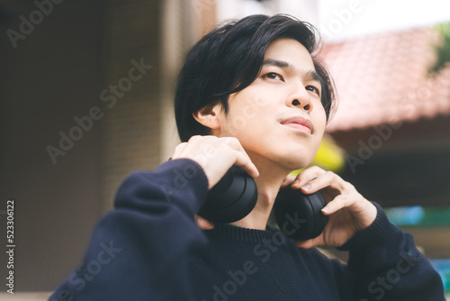 Photography Portrait of young adult asian men with black short hair using headphone listen m