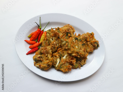 Bala-bala or Bakwan or vegetable fritter, traditional Indonesian snack, made from carrot, cabbage and bean sprouts and mix with flour and deep fried. Served with chillies and peanuts sauce