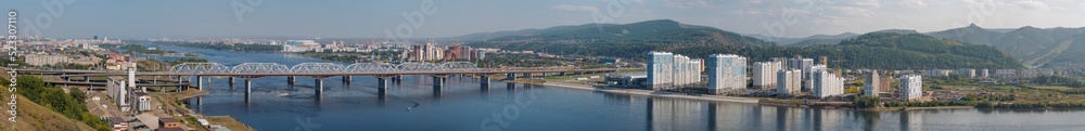 Panorama of a large city located on both banks of a wide river. Summer day