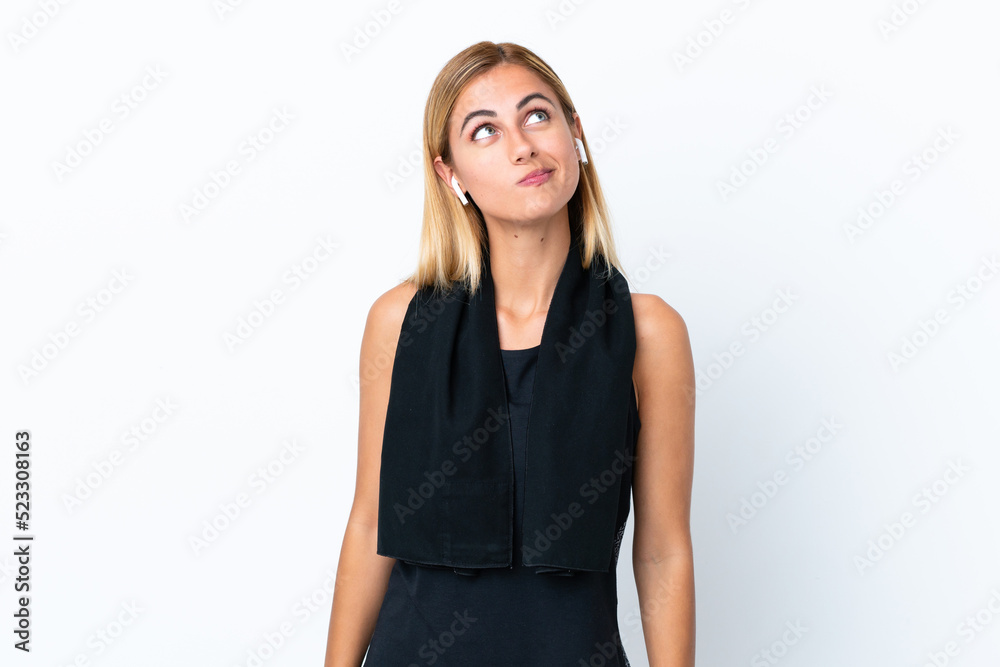 Fototapeta premium Blonde Uruguayan sport girl isolated on white background and looking up