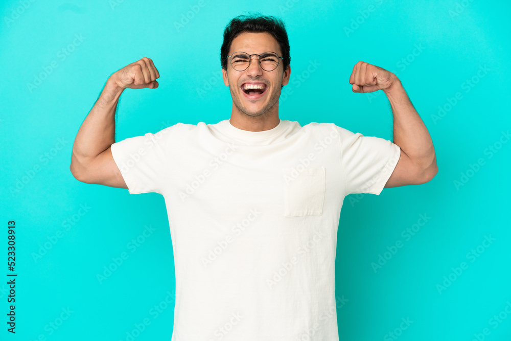 Caucasian handsome man over isolated blue background doing strong gesture