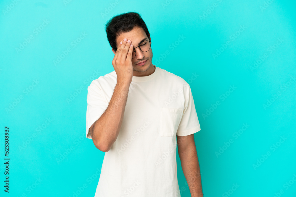 Caucasian handsome man over isolated blue background with headache