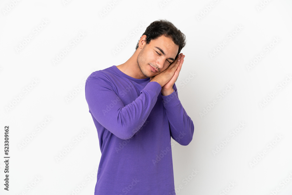 Caucasian handsome man over isolated white background making sleep gesture in dorable expression Caucasian handsome man over isolated white background making sleep gesture in dorable expression