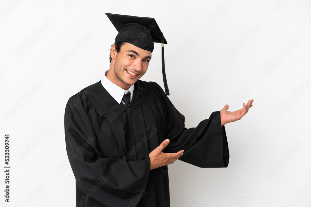 Young university graduate over isolated white background extending hands to the side for inviting to come Young university graduate over isolated white background extending hands to the side for inviting to come