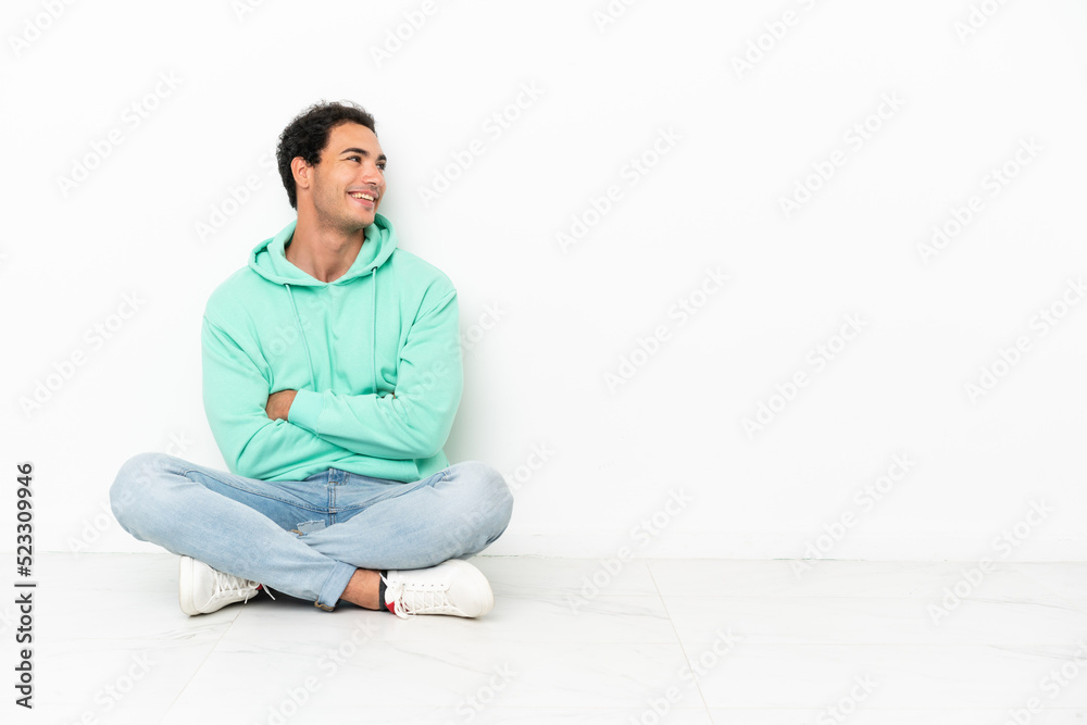 Caucasian handsome man sitting on the floor happy and smiling Caucasian handsome man sitting on the floor happy and smiling