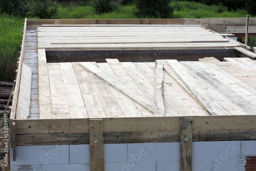 A wooden formwork for a ceiling of a first floor, a stairwell rough opening, walls made of autoclaved aerated concrete photo