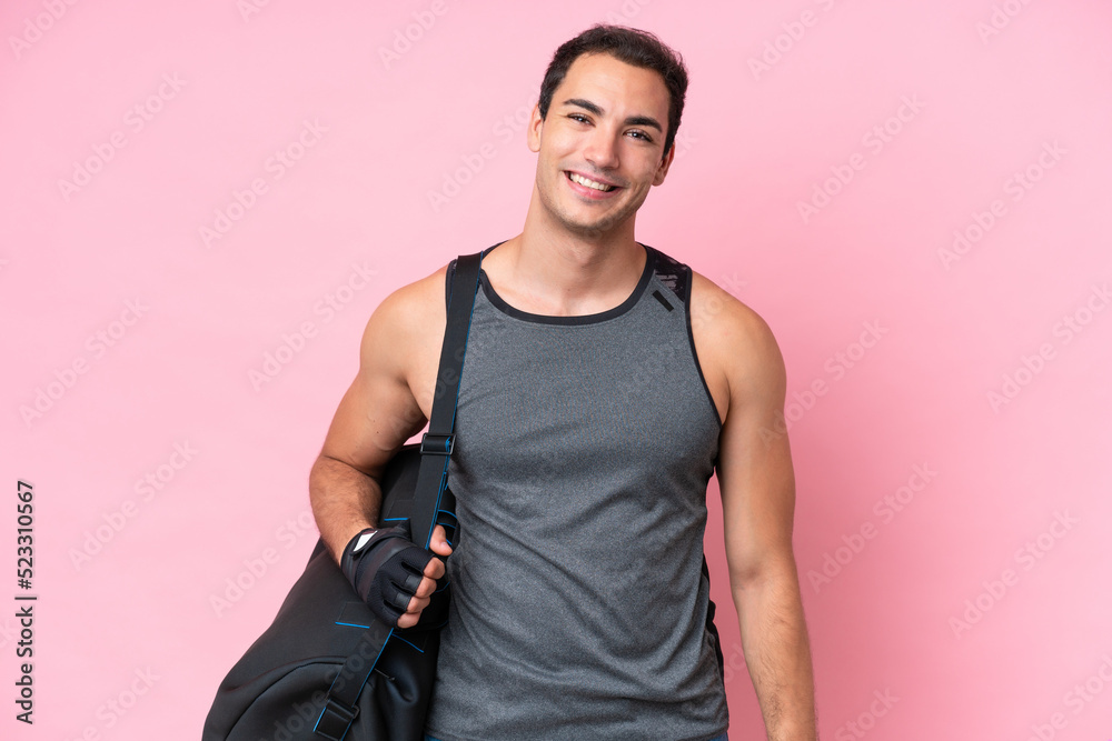 Young sport caucasian man with sport bag isolated on pink background laughing Young sport caucasian man with sport bag isolated on pink background laughing