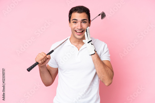 Young golfer player man isolated on pink background with surprise and shocked facial expression
