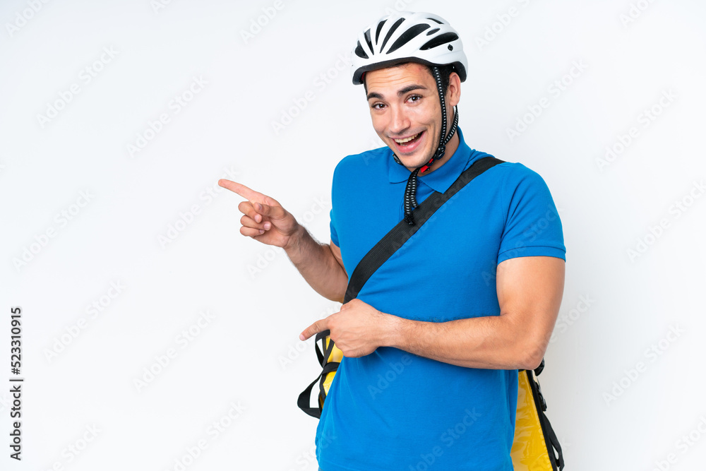 Young caucasian man with thermal backpack isolated on white background surprised and pointing side Young caucasian man with thermal backpack isolated on white background surprised and pointing side