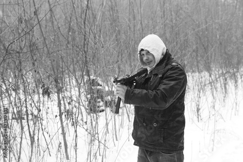 A man with vintage submachine gun in the forest