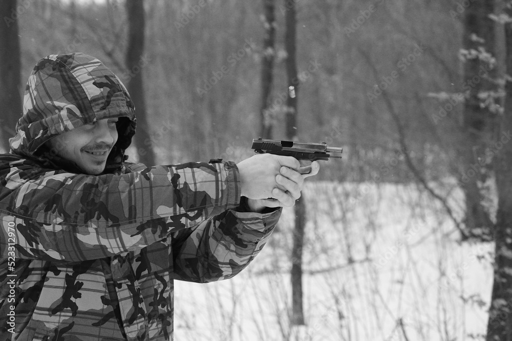 Fototapeta premium Man shooting with a pistol in the forest