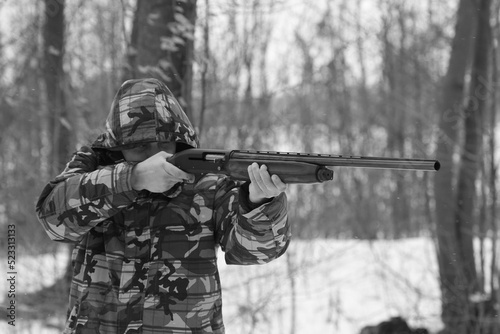 A hunter with a shotgun in the forest
