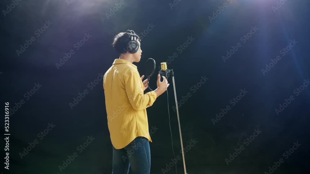 Back View Of A Young Boy With Headphone Singing Into A Condenser Microphone On The White Smoke Black Background
Back View Of A Young Boy With Headphone Singing Into A Condenser Microphone On The White Smoke Black Background
