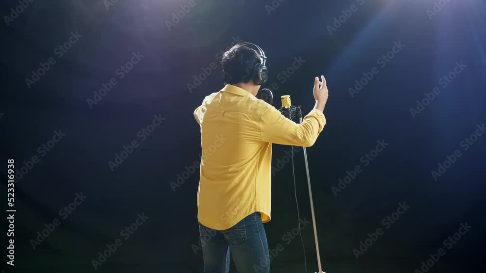 Back View Of A Young Boy With Headphone Rapping Into A Condenser Microphone On The White Smoke Black Background
Back View Of A Young Boy With Headphone Rapping Into A Condenser Microphone On The White Smoke Black Background