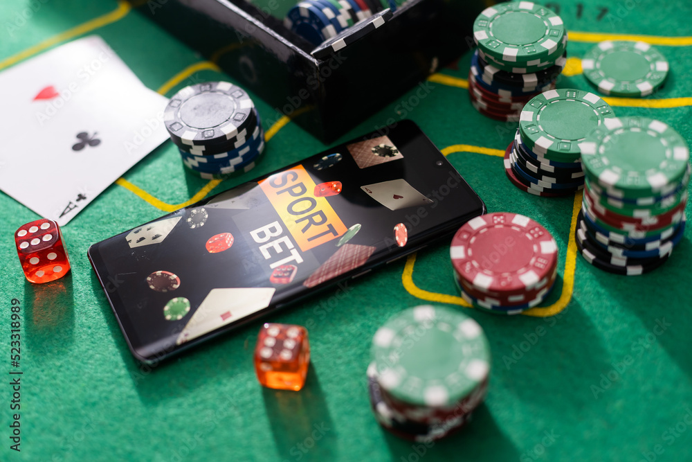 Online poker concept. Smartphone and poker chips on a green background. Poker online banner. Copy space. Vignette. Place for text. Gambling. Background Online poker concept. Smartphone and poker chips on a green background. Poker online banner. Copy space. Vignette. Place for text. Gambling. Background