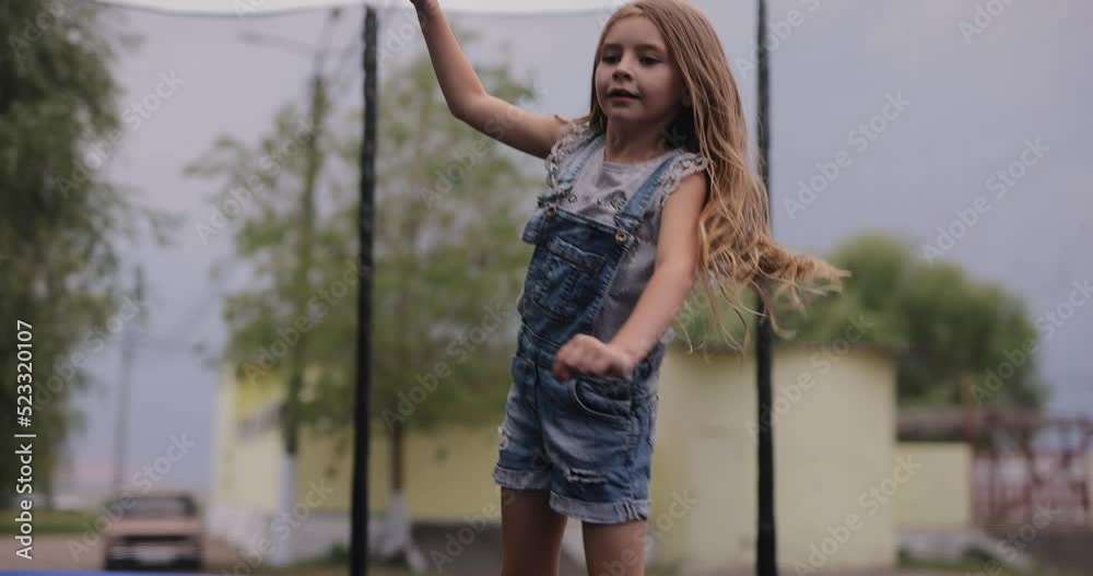Little girl jumping on a trampoline, slow motion Little girl jumping on a trampoline, slow motion
