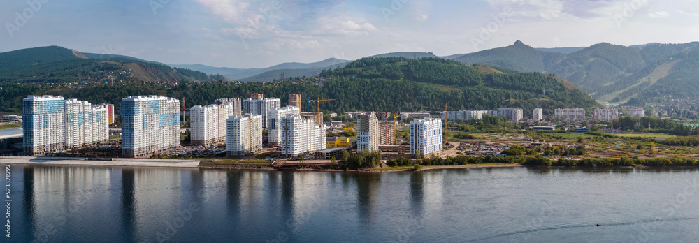 Panorama of a residential area located on banks of a wide river at the summer day