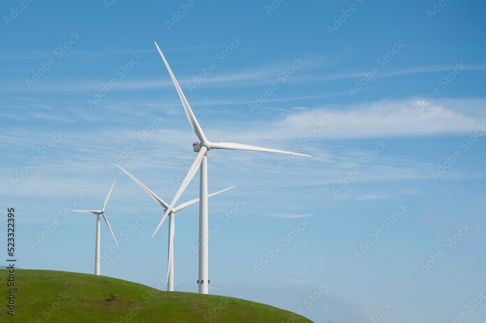 Wind turbines and blue sky. Green landscape with wind generators turbines, Denmark. Renewable energy concept Wind turbines and blue sky. Green landscape with wind generators turbines, Denmark. Renewable energy concept