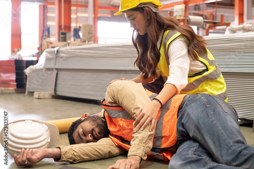 Men worker unconscious and pass out from the accident that happen inside of industrial factory while his co-worker come to give emergency assistance and help. Accident in warehouse, production line. photo
