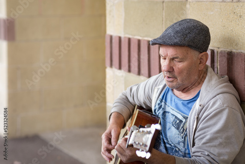 Old guy singing and playing guitar photo