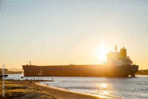 Coal ship coming into Newcastle Harbour at sunset photo
