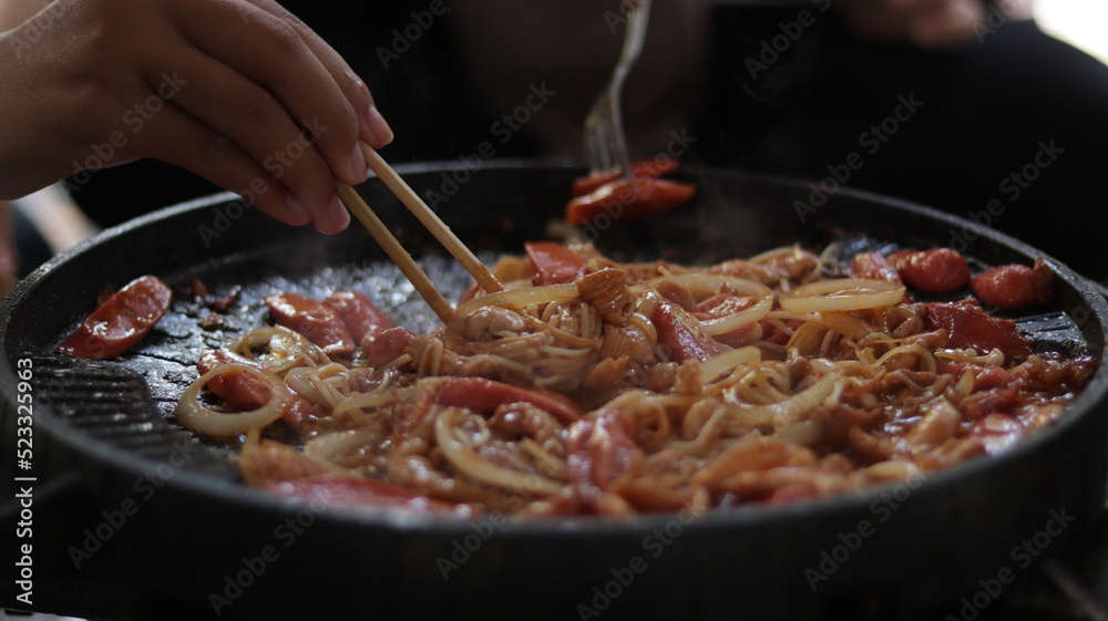 some delicious grilled meats and sausages with added onions and barbecue sauce ready to eat using chopsticks with friends and family some delicious grilled meats and sausages with added onions and barbecue sauce ready to eat using chopsticks with friends and family