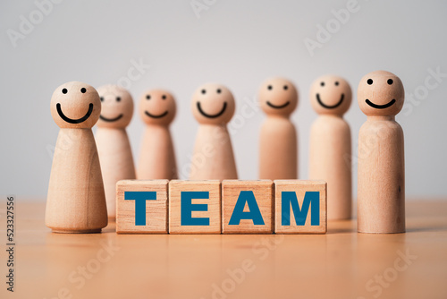 Wooden figure standing around team wording for business teamwork and corporate concept.