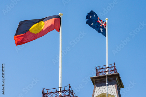 Looking up at an Australian and Aboriginal flag flying next to one another photo