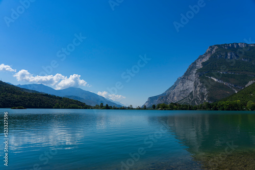 Toblino lake, Trentino Alto Adige. Marvelous large mountain lake in the hills of northern Italy. Flat water surface and clear blue sky. Popular swimming lake.