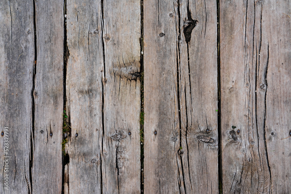 Fototapeta premium Texture of ground wooden planks. Old wood damaged by time and cracks along the boards.