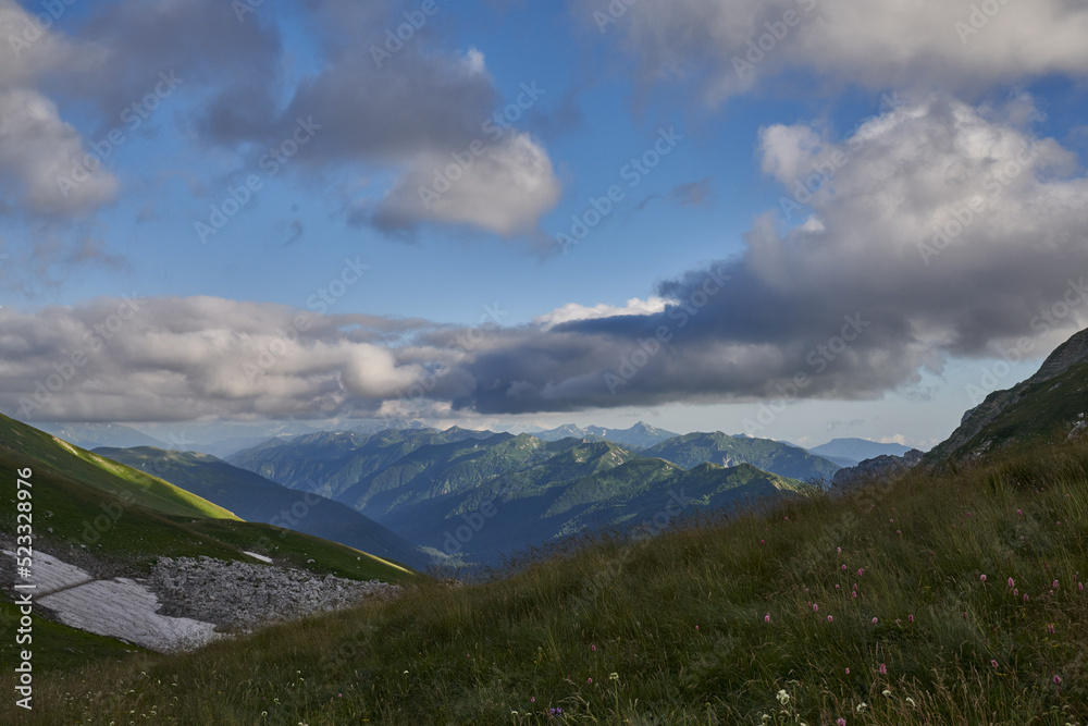 Fototapeta premium green mountains against the sky and sunset