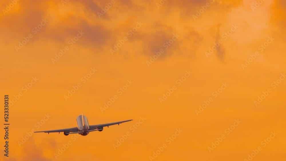 Cinematic shot of an Airplane flies away in a fiery golden sunset, view from the back. Tourism and travel concept Cinematic shot of an Airplane flies away in a fiery golden sunset, view from the back. Tourism and travel concept