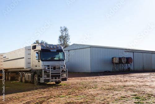 Semi trailer truck near shed on a farm