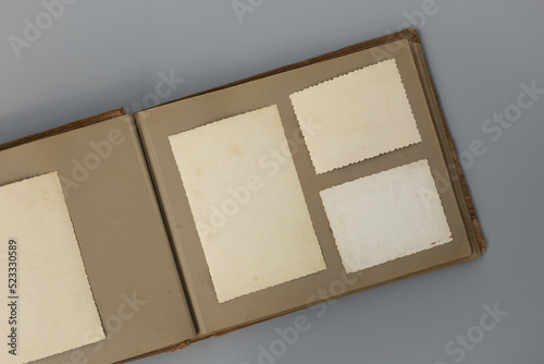 Clear blank photo frames to placed your pictures or text on old family album on grey background in retro style. Family traditions, memories and nostalgia concept. Antique album with old photos.