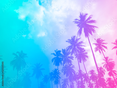 Coconut palm trees on summer colorful sky, beautiful tropical background with space, bottom view. Gradient colors with light blue, purple and pink.